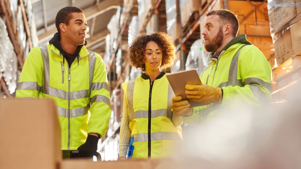 L'équipe de l'entrepôt discute des stratégies logistiques du dernier kilomètre pour les livraisons de e-commerce en période de haute saison.